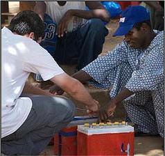 Photo of two men hooking up 12 Volt batteries